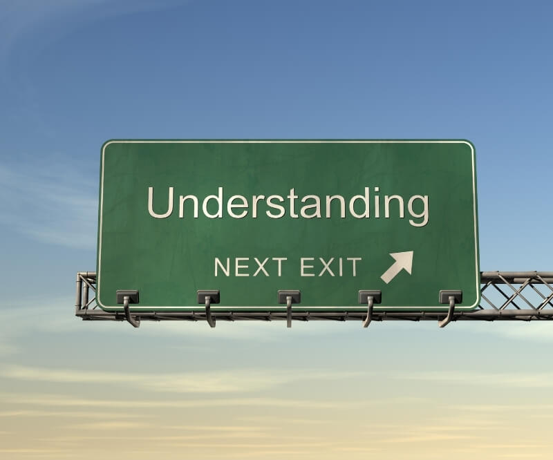 Zielony drogowskaz Understanding: Rozumienie na niebieskim niebie – metafora ścieżki do panowania nad emocjami w inteligencji emocjonalnej.